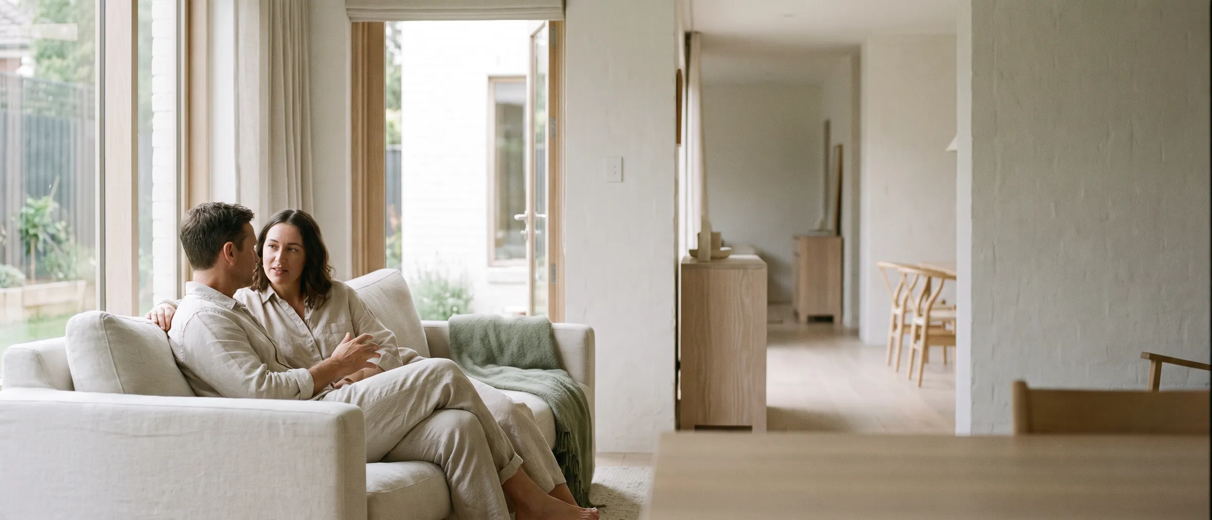 A couple sitting together on a sofa in a bright living room