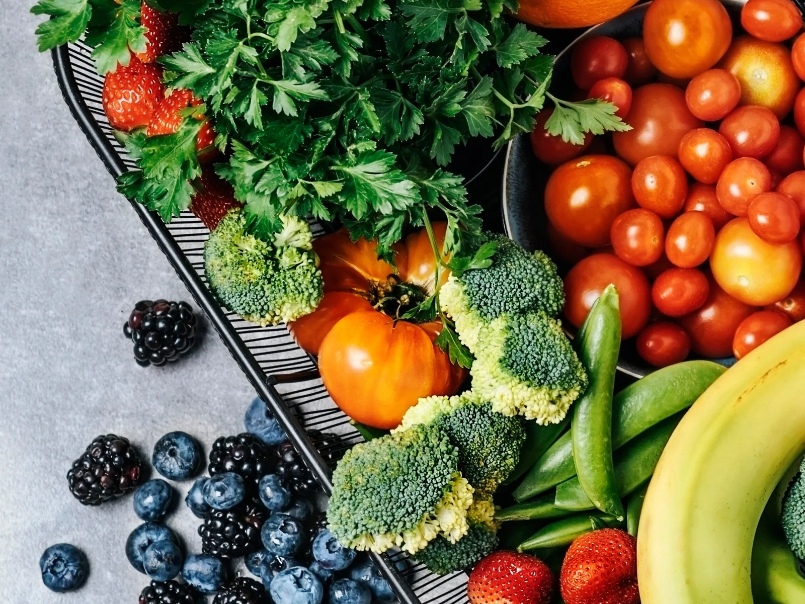 A spread of fresh vegetables, fruit and berries