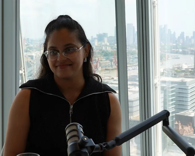 Genetic counsellor Huafrin Kotwal at a microphone, the London skyline behind her