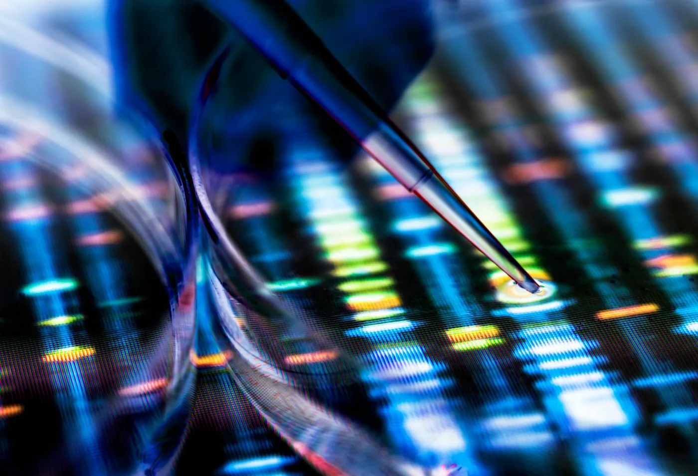 A pipette above a glowing DNA sequencing read out