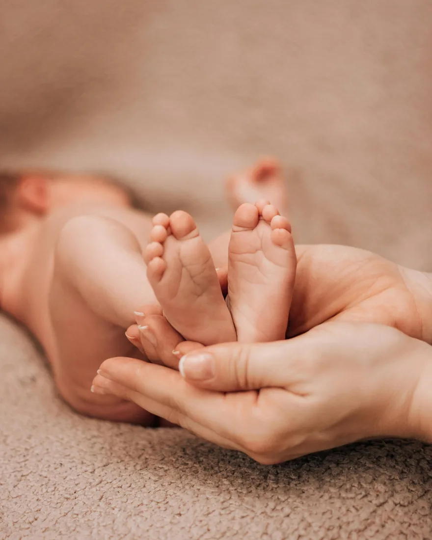 A parent holding a newborn’s feet