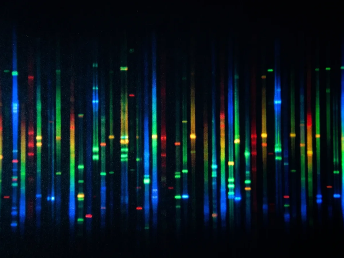 Coloured sequencing reads glowing in vertical lanes on black